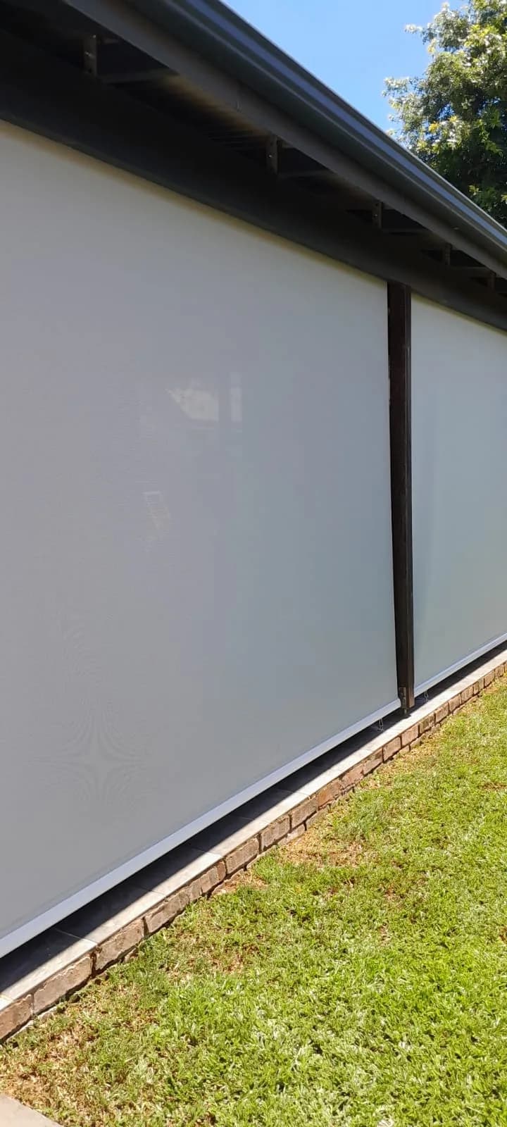 Exterior sunscreen awning blinds fitted along a patio roofline